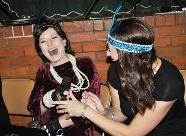 Two guests in 1920s dress laughing together