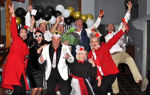 A dressed-up team cheering under balloons