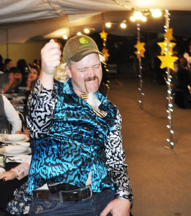 A guest in a bright shirt dancing at his table